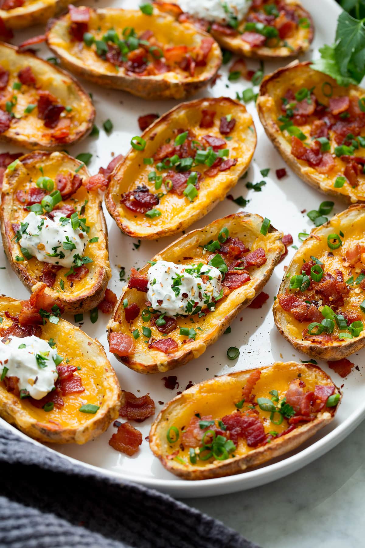 Potato skins shown from a side angle on a large serving platter.